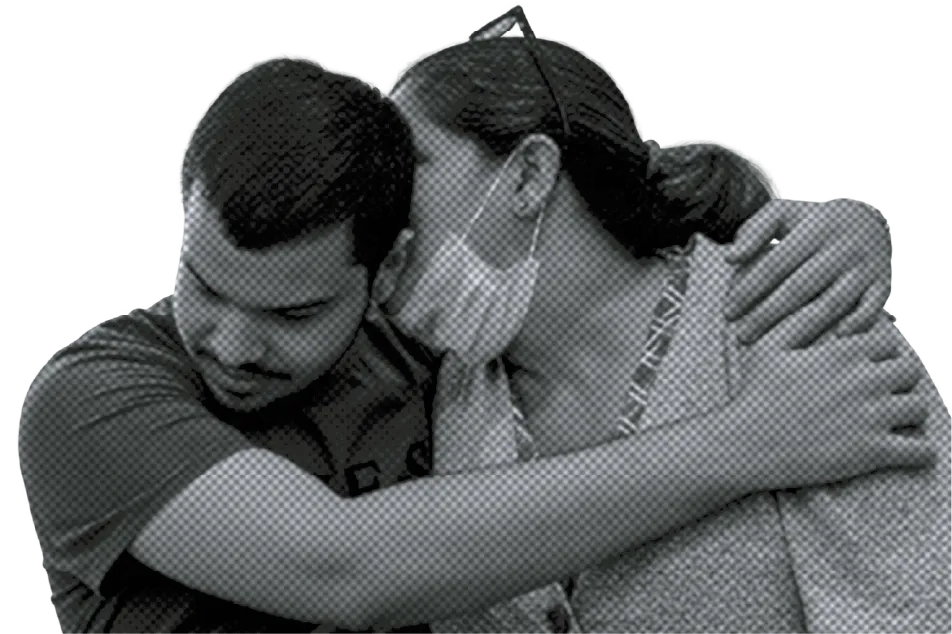 A mother embraces her son